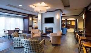 a hotel lobby with a fireplace and tables and chairs at Hampton Inn Bennington in Bennington