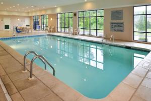 a large swimming pool with blue water in a building at Hampton Inn Milford in Milford
