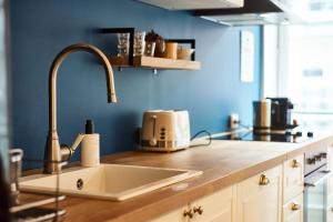 a kitchen with a sink and a blue wall at Charmant cocon lyonnais Sathonay-Terreaux in Lyon