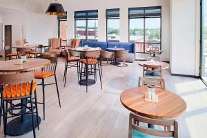 un restaurante con mesas y sillas de madera y ventanas en Hilton Garden Inn Providence, en Providence