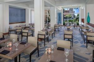 un ristorante con tavoli e sedie in legno e finestre di DoubleTree by Hilton Los Angeles/Commerce a Commerce