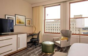 ein Hotelzimmer mit einem Bett, einem Schreibtisch und einem TV in der Unterkunft Doubletree By Hilton Youngstown Downtown in Youngstown