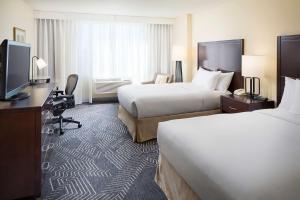 a hotel room with two beds and a television at DoubleTree by Hilton Los Angeles/Commerce in Commerce