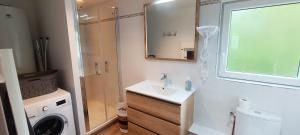 a bathroom with a sink and a washing machine at La Grange in Auberville