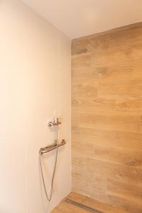 een douchecabine in een badkamer met een houten muur bij Agroturismo Montefrío in Urnieta