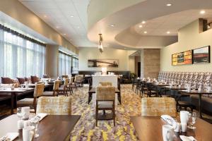 a restaurant with tables and chairs in a room at Hilton East Brunswick in East Brunswick