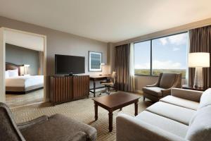 a hotel room with a bed and a living room at Hilton East Brunswick in East Brunswick
