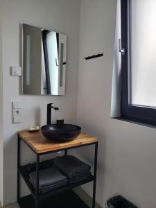 a bathroom with a black sink and a mirror at Ferienwohnung Schlossterrassen 4b in Pouch