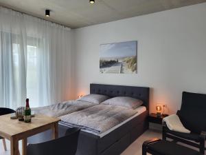 ein Schlafzimmer mit einem großen Bett und einem Tisch und einem sidx sidx in der Unterkunft Ferienwohnung Schlossterrassen 4b in Pouch