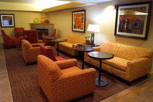 a waiting room with couches and chairs and a fireplace at Hampton Inn Altoona in Altoona