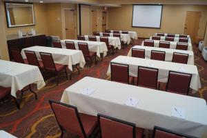 Hampton Inn Altoona في ألتونا: قاعة اجتماعات مع طاولات وكراسي وشاشة
