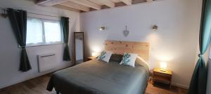 a bedroom with a bed with two pillows and a window at La Grange in Auberville
