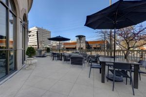 un patio con mesas, sillas y sombrillas en Homewood Suites Nashville Vanderbilt, en Nashville