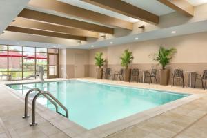 una piscina en una habitación de hotel con mesas y sillas en Home2 Suites By Hilton Florence Cincinnati Airport South en Florence