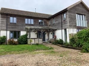 ein Haus mit einer Veranda und einem Hof in der Unterkunft Withy Farm in Canterbury