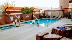 een zwembad met een boomstronk voor een gebouw bij Hampton Inn Moab in Moab