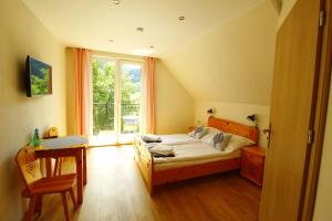 sypialnia z łóżkiem, biurkiem i oknem w obiekcie Kasiablanka w mieście Szczawnica