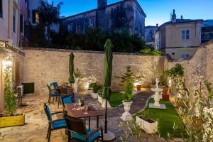 a patio with tables and chairs and plants at Volto Suites in Corfu Town