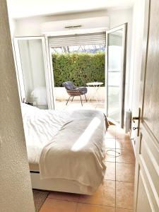a bedroom with a bed and a balcony with a chair at A Sainte marguerite in Nice