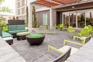 un patio con muebles, mesas y sillas en Home2 Suites By Hilton Orlando South Park, en Orlando