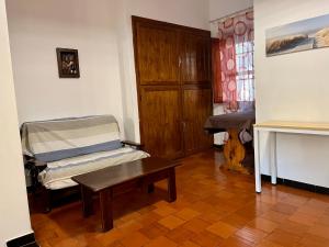 um quarto com uma mesa, uma cadeira e uma secretária em Villetta Porto Pino 30 mt dalla spiaggia em Porto Pino