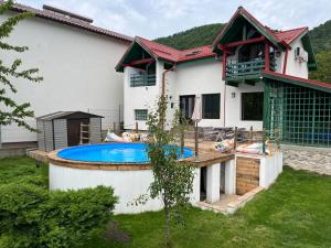 a house with a swimming pool in the yard at Casuta Anei in Eşelniţa