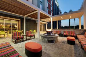 坦帕Home2 Suites By Hilton Brandon Tampa的带椅子和桌子的露台，还有火坑