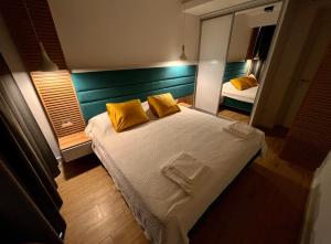 a bedroom with a bed with yellow pillows and a mirror at Мamma Mia Аpartments in Budva