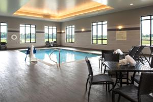 a pool with tables and chairs in a hotel lobby at Hampton Inn & Suites Pittsburg Kansas Crossing in Pittsburg