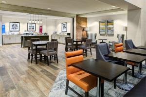 a restaurant with tables and chairs and a kitchen at Hampton Inn & Suites Pittsburg Kansas Crossing in Pittsburg