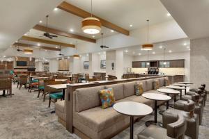un restaurante con sofá, mesas y un bar en Homewood Suites by Hilton Moab en Moab