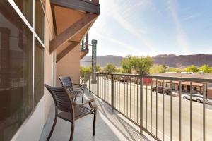 two chairs on a balcony with a view of a street at Homewood Suites by Hilton Moab in Moab