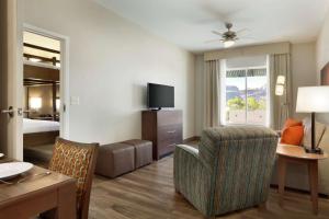 a hotel room with a bed and a living room at Homewood Suites by Hilton Moab in Moab