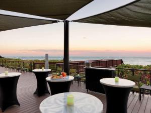 DoubleTree Suites by Hilton Melbourne Beach Oceanfront في ملبورن: فناء به طاولات وكراسي ومطل على المحيط