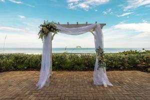 a wedding arch with flowers in front of the beach at Hilton Melbourne Beach Oceanfront in Melbourne