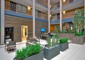 丹佛Embassy Suites by Hilton Denver Central Park的酒店大堂里摆放着桌椅