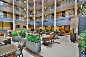 un vestíbulo vacío de un hotel con mesas y sillas en Embassy Suites by Hilton Denver Central Park, en Denver