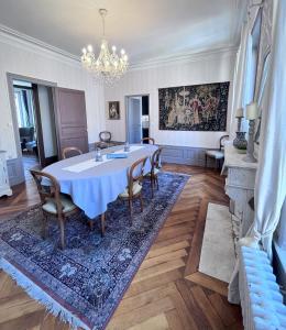 une salle à manger avec une table, des chaises et un lustre dans l'établissement Résidence de la Marquise, à Nancy