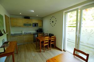 a kitchen with a wooden table and a dining room at Kasiablanka in Szczawnica