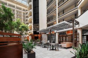 un patio extérieur avec des tables et des chaises dans un bâtiment dans l'établissement Embassy Suites by Hilton Nashville Airport, à Nashville