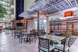 a restaurant with tables and chairs and a couch at Embassy Suites by Hilton Nashville Airport in Nashville