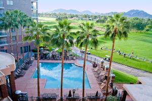 widok na basen w ośrodku z palmami w obiekcie Embassy Suites by Hilton Phoenix Scottsdale w mieście Phoenix