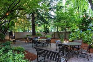 eine Terrasse mit Tischen, Stühlen und Bäumen in der Unterkunft DoubleTree by Hilton Portland in Portland