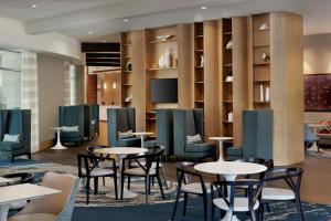 a restaurant with tables and chairs and a tv at Hampton Inn & Suites Teaneck/Glenpointe in Teaneck