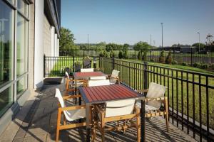 a patio with tables and chairs and a fence at Homewood Suites By Hilton Teaneck Glenpointe in Teaneck