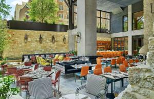 un ristorante con tavoli e sedie di fronte a un edificio di Canopy By Hilton San Antonio Riverwalk a San Antonio