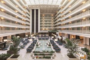 Embassy Suites by Hilton Brea - North Orange County في بري: لوبي فارغ من مبنى به طاولات وكراسي