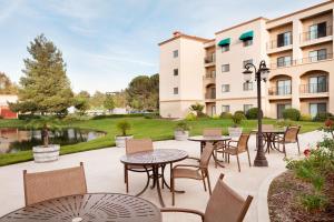 a patio with tables and chairs in front of a building at Embassy Suites by Hilton Temecula Valley Wine Country in Temecula