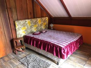 una camera da letto con un letto in una stanza con pareti in legno di Sítio Chalé 3Ipes a Senador José Bento Altre 46 foto