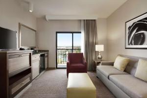 a living room with a couch and a tv at Embassy Suites by Hilton Temecula Valley Wine Country in Temecula